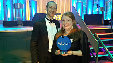 Photo of Charlotte accepting award on stage, with Medivet Senior Partner Adi Nell