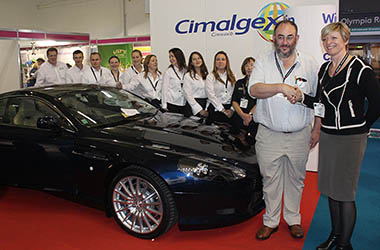 Aston winner standing next to car