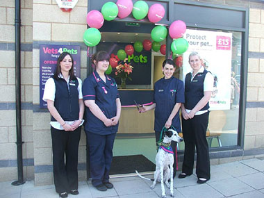 Staff cutting ribbon at entrance to new practice