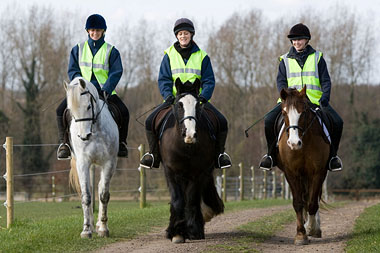 3 riders on horseback in a row