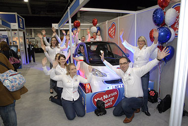 Photo showing winning nurse next to car