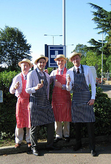 4 guys in stripey overalls holding ice cream cones