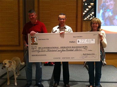 Bark Busters staff presenting cheque to SPCA International