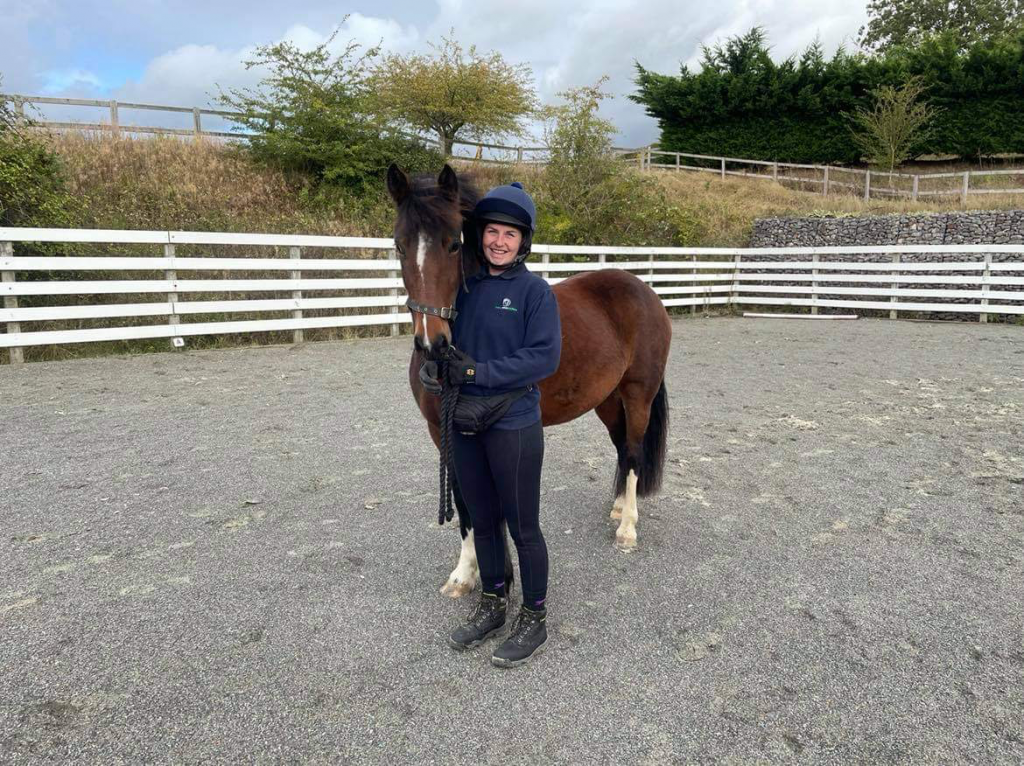 About to go out to rehomer. Rider standing next to horse in paddock