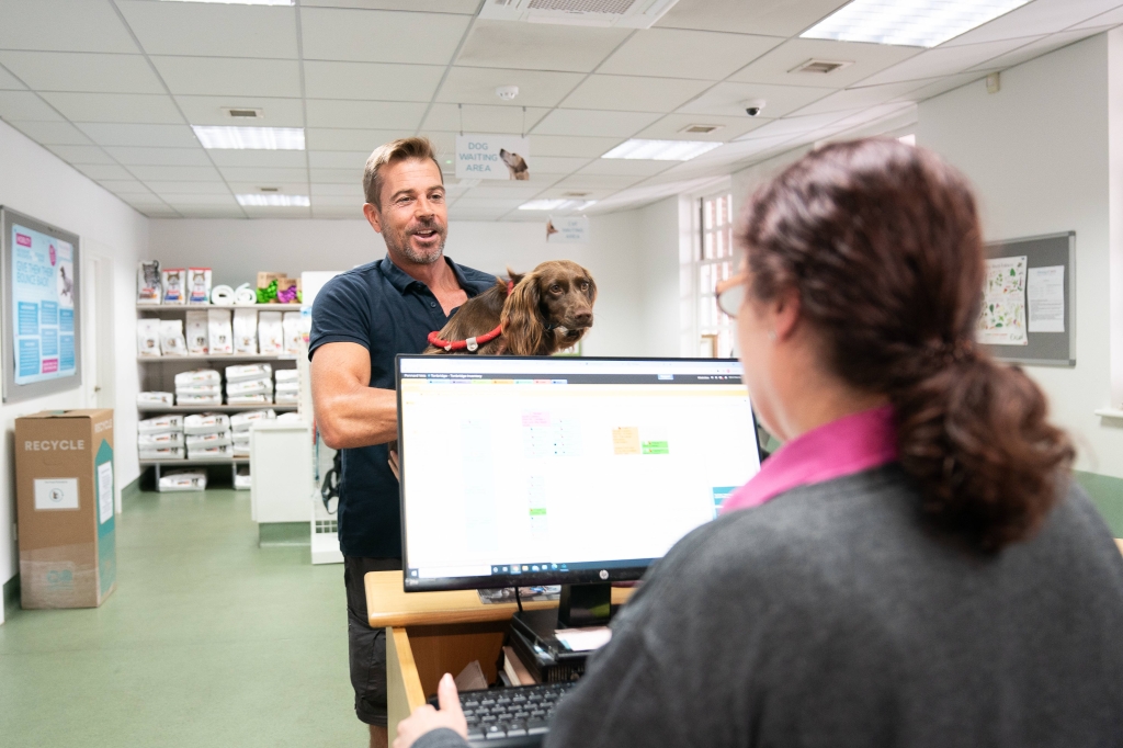 Customer Andrew Rankine with pet Millie celebrate the IIC award at Pennard Vets.