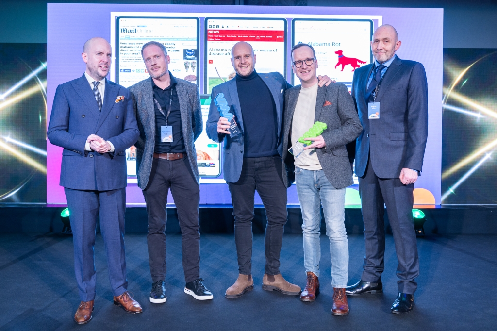 R&Co Communications won the PR Campaign of the Year at the Veterinary Marketing Association Awards 2024. Pictured with host Tom Allen are, from left, R&Co managing director Peter Robinson and account directors Tom Payne and Ian Gallagher