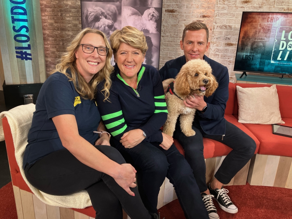 Kelly McMaster, Clare Balding and Scott Mills sitting with a dog on a couch